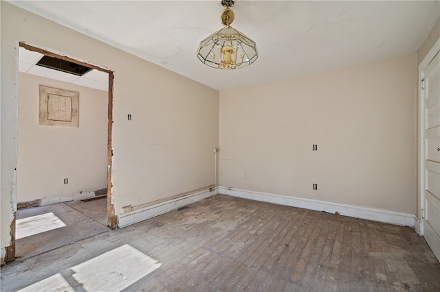 spare room with a notable chandelier and hardwood / wood-style flooring