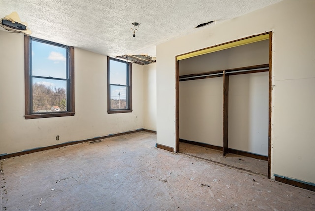 unfurnished bedroom with a textured ceiling and a closet