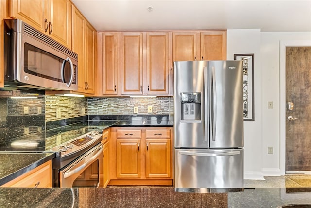 kitchen with backsplash, dark stone countertops, and appliances with stainless steel finishes