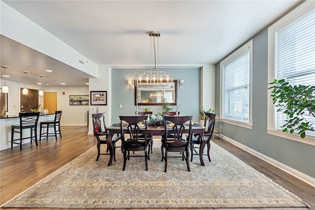 dining space with a notable chandelier and dark hardwood / wood-style flooring