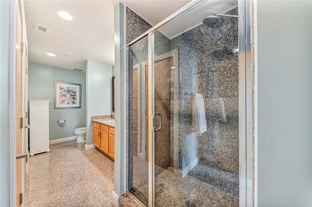 bathroom with a shower with shower door, vanity, and toilet