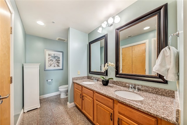 bathroom with double vanity and toilet