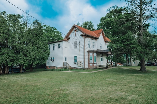 rear view of property with a lawn