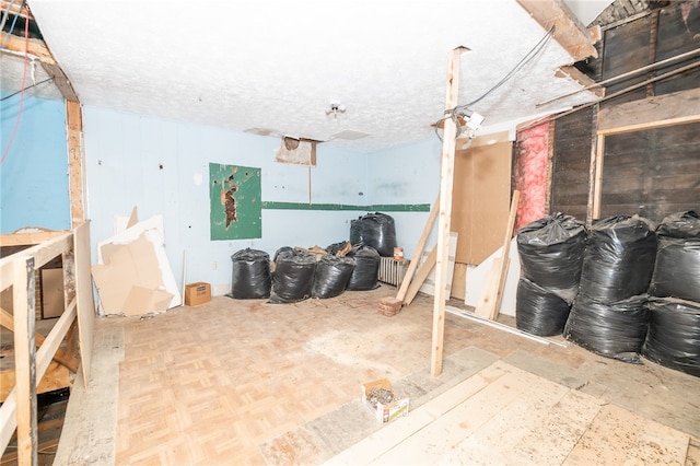 basement featuring a textured ceiling and parquet floors