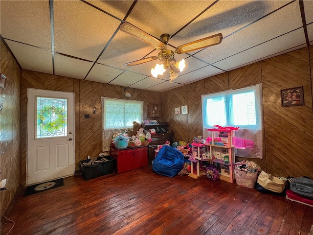 miscellaneous room featuring wooden walls, a drop ceiling, and wood-type flooring