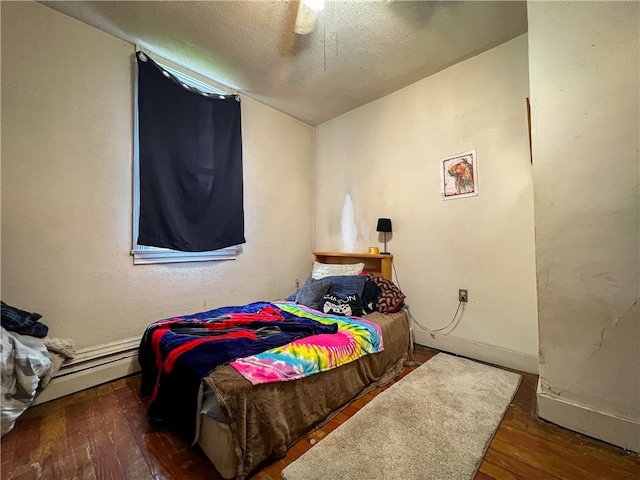 bedroom with dark hardwood / wood-style floors, a baseboard heating unit, ceiling fan, a textured ceiling, and lofted ceiling