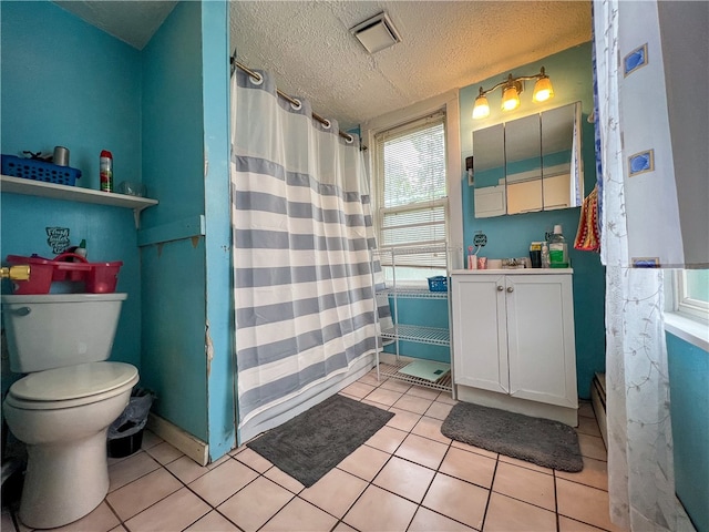 bathroom with tile flooring, vanity, toilet, and a textured ceiling