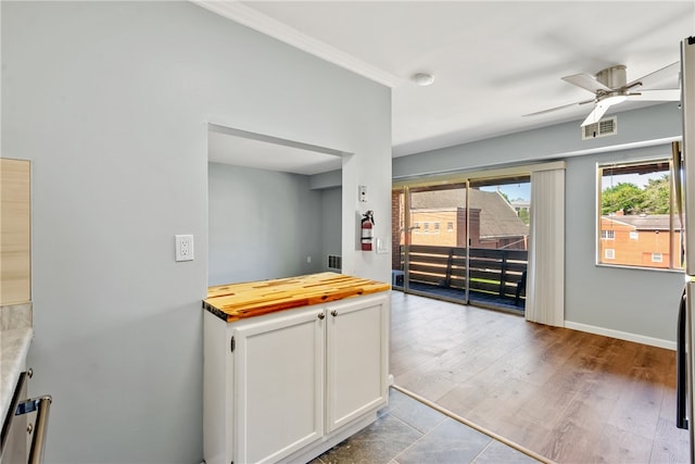 kitchen featuring hardwood / wood-style flooring, white cabinetry, ceiling fan, and ornamental molding