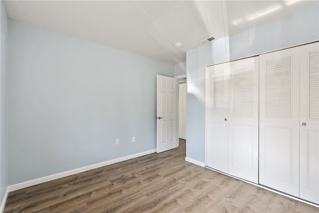 unfurnished bedroom with a closet and hardwood / wood-style floors