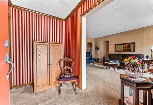 interior space featuring a paneled ceiling and wood walls