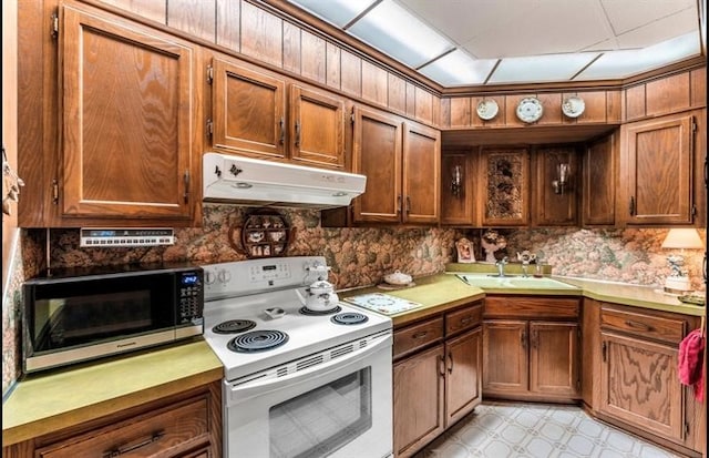 kitchen featuring backsplash, sink, electric range, and light tile floors