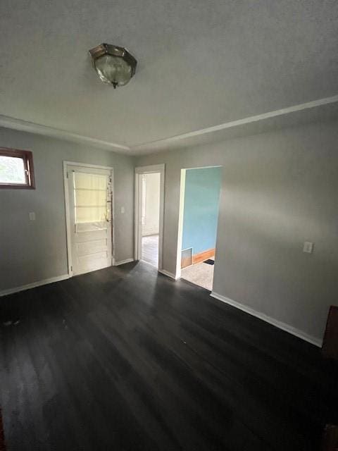 empty room featuring wood finished floors and baseboards