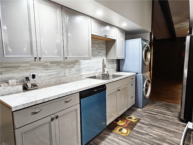 kitchen featuring stacked washer and clothes dryer, sink, dark hardwood / wood-style floors, and stainless steel appliances