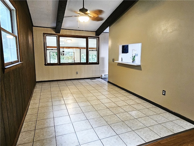 unfurnished room featuring a baseboard heating unit, beamed ceiling, ceiling fan, and light tile flooring