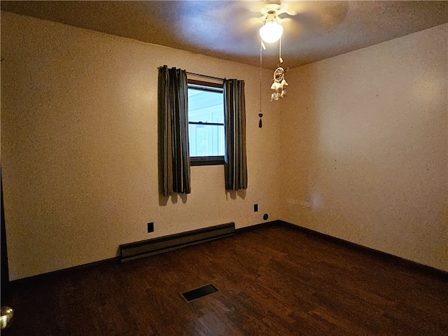 empty room with ceiling fan, baseboard heating, and dark wood-type flooring