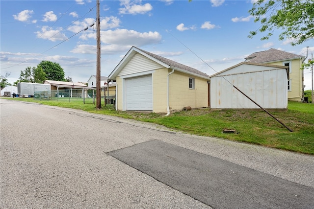 view of side of home with an outdoor structure, a lawn, and a garage