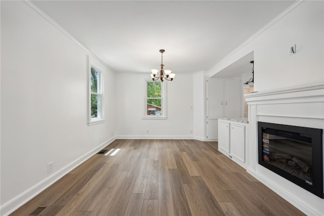 unfurnished living room with a chandelier, ornamental molding, and wood-type flooring