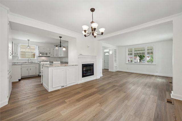 unfurnished living room featuring crown molding, hardwood / wood-style flooring, and a chandelier