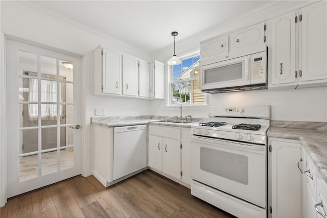 kitchen with white appliances, hardwood / wood-style flooring, white cabinetry, and pendant lighting