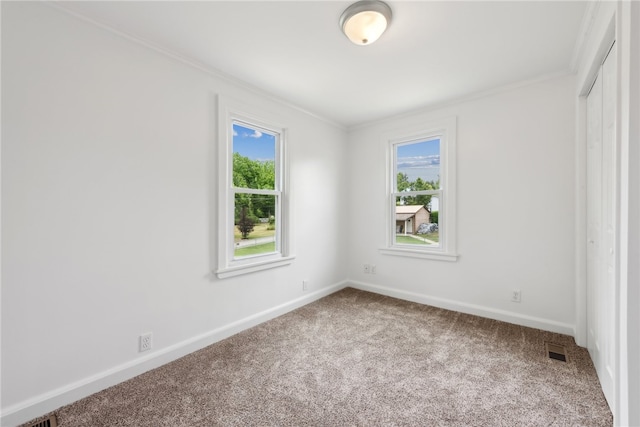 carpeted spare room featuring crown molding