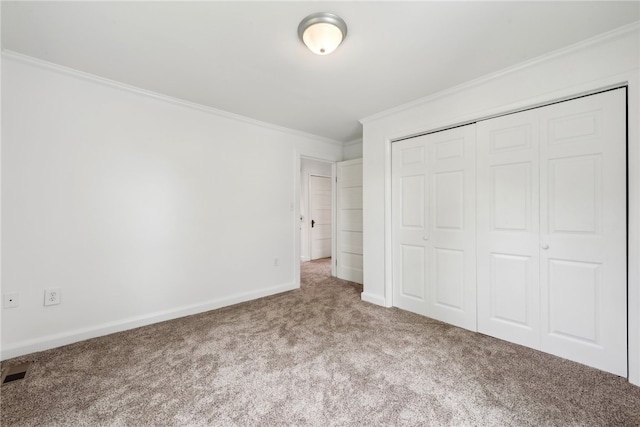 unfurnished bedroom featuring a closet, carpet floors, and crown molding