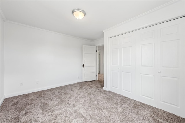 unfurnished bedroom with crown molding, a closet, and carpet floors