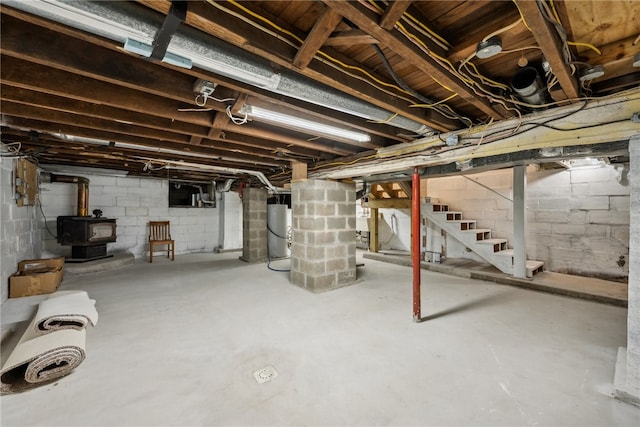 basement featuring gas water heater and a wood stove