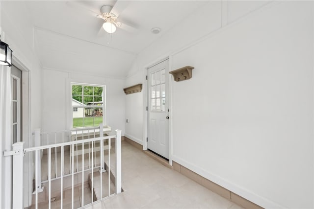 corridor with vaulted ceiling and light tile floors