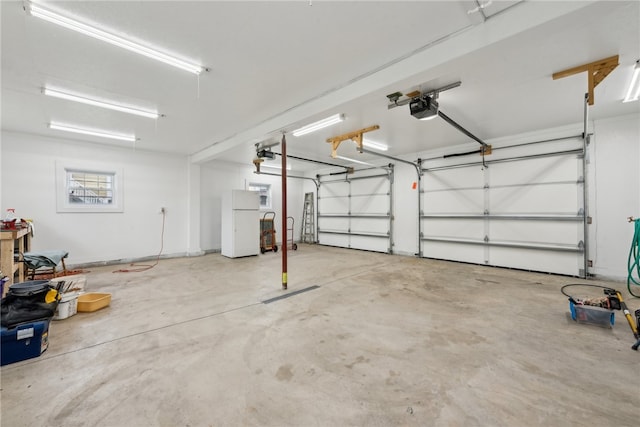 garage with white refrigerator and a garage door opener