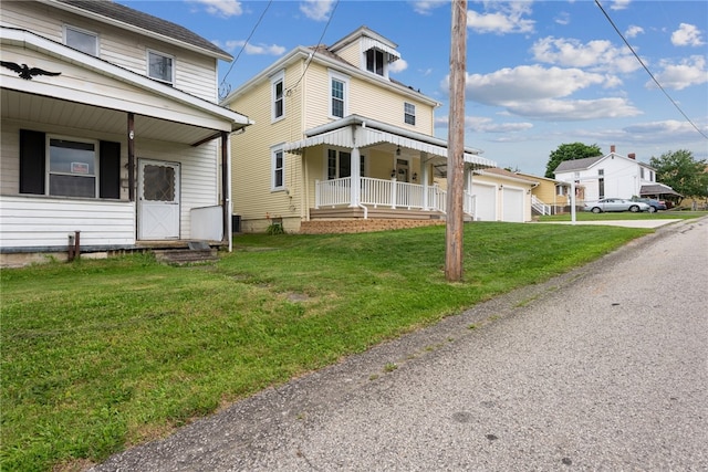 view of front of home featuring a garage, a front yard, and covered porch