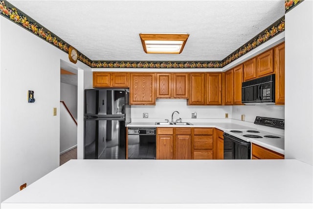 kitchen featuring sink, a textured ceiling, and black appliances