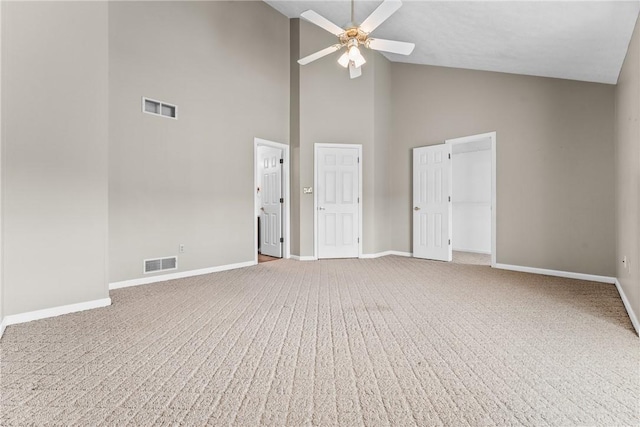 carpeted empty room featuring ceiling fan and high vaulted ceiling