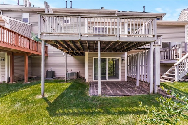 back of property featuring a wooden deck, a yard, and central AC