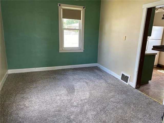 unfurnished room featuring dark colored carpet