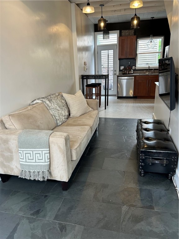 living room featuring sink and dark tile floors