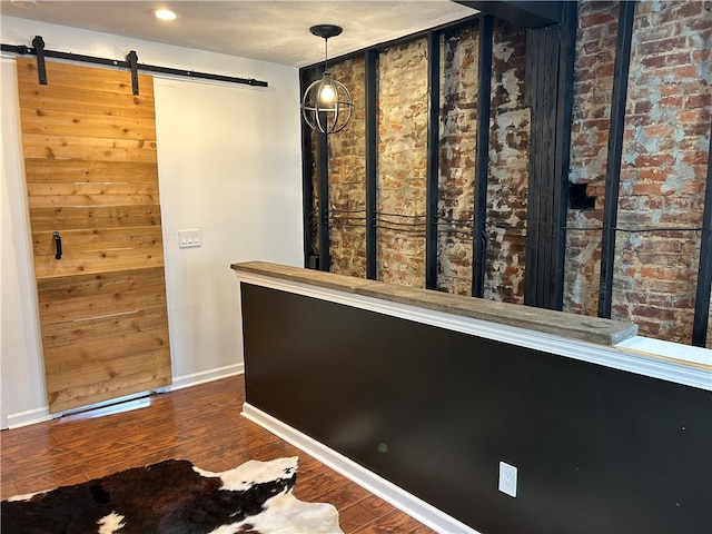 interior space featuring a barn door and dark hardwood / wood-style flooring