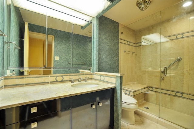 bathroom featuring tile patterned floors, a shower with door, vanity, and toilet