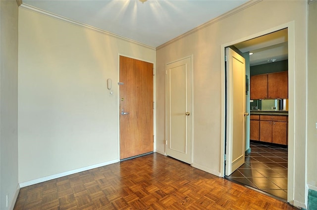 spare room featuring dark parquet flooring and crown molding