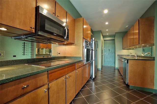 kitchen featuring dark tile patterned floors, sink, and appliances with stainless steel finishes