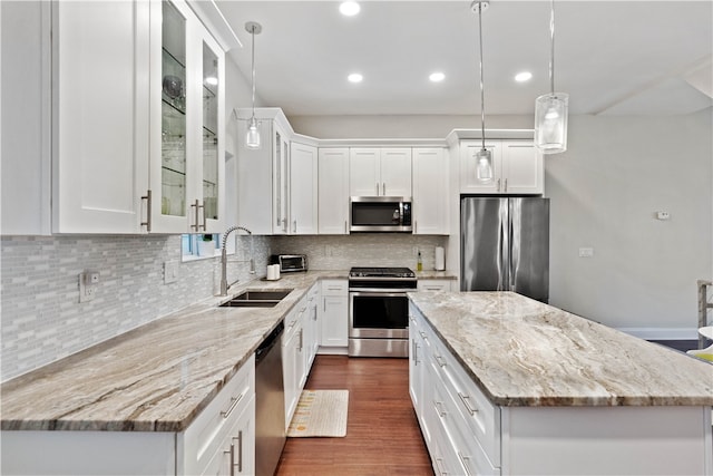 kitchen featuring white cabinets, appliances with stainless steel finishes, pendant lighting, and sink