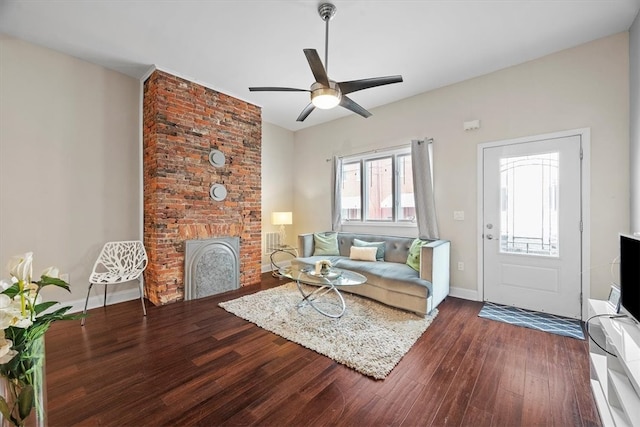 living room featuring dark hardwood / wood-style floors, a brick fireplace, and ceiling fan