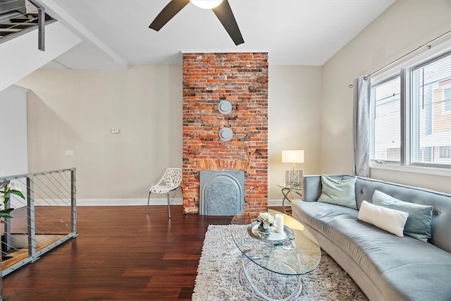 living room with dark hardwood / wood-style flooring, a brick fireplace, and ceiling fan