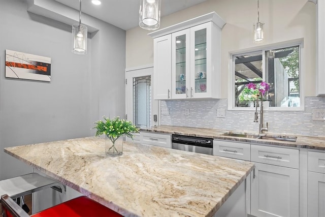 kitchen with pendant lighting, white cabinetry, sink, and stainless steel dishwasher