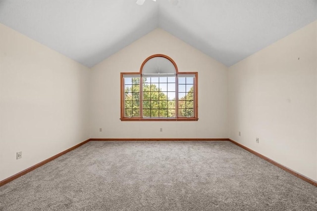 unfurnished room featuring carpet flooring and vaulted ceiling