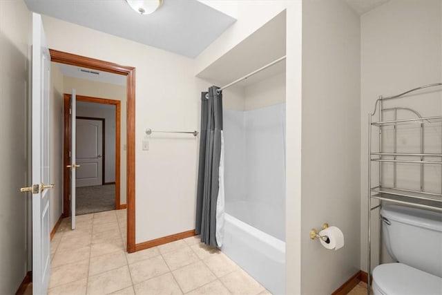 bathroom featuring tile patterned floors, toilet, and shower / tub combo with curtain