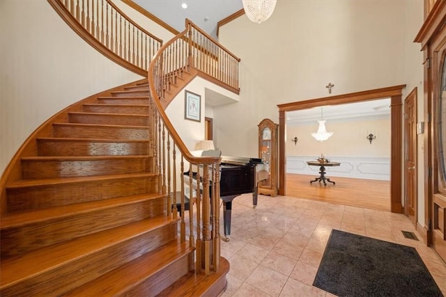 tiled entryway featuring a high ceiling and ornamental molding