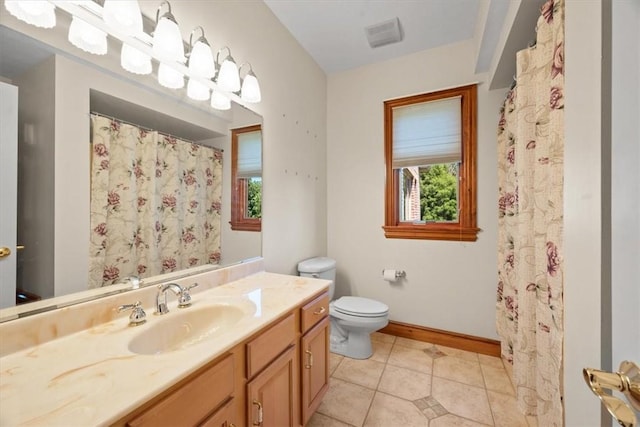 bathroom with tile patterned flooring, vanity, and toilet