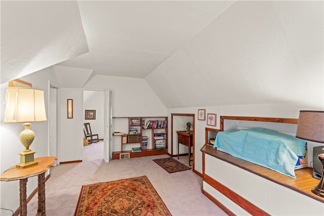 bedroom with vaulted ceiling and light colored carpet