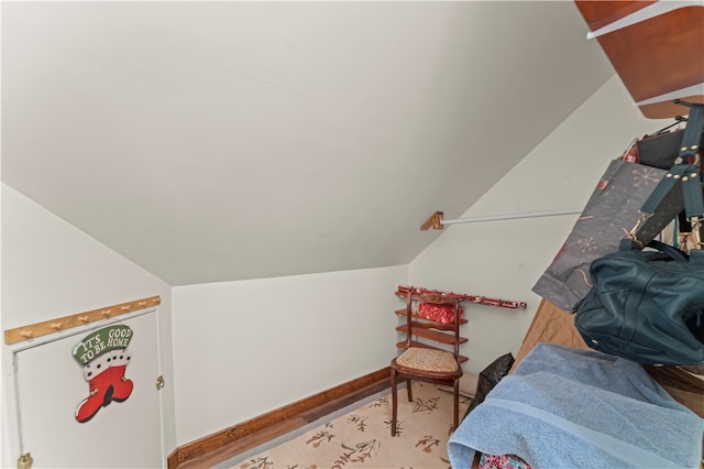 interior space with hardwood / wood-style flooring and vaulted ceiling