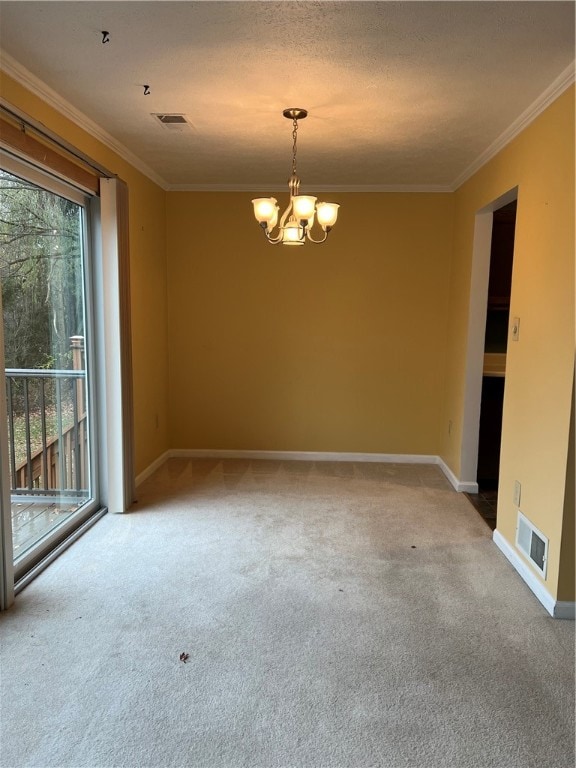 spare room featuring a chandelier, a textured ceiling, carpet floors, and ornamental molding